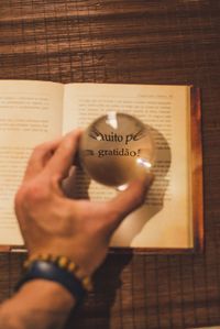 Close-up of hand holding book with text