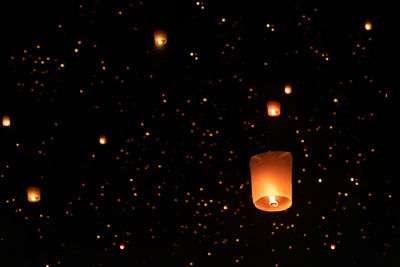 Low angle view of illuminated lamp against dark sky