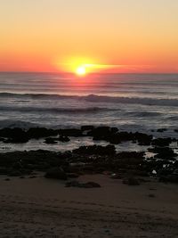 Scenic view of sea against dramatic sky during sunset