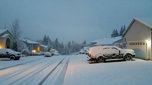 Car on snow covered road against sky