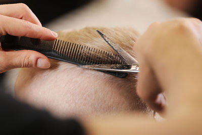 Cropped hands cutting man hair