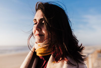 Portrait of woman at beach against sky