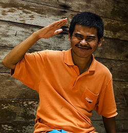 Portrait of smiling man standing on wood