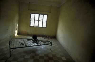 Bed on checked patterned floor at prison cell
