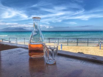 Water on table by sea against sky