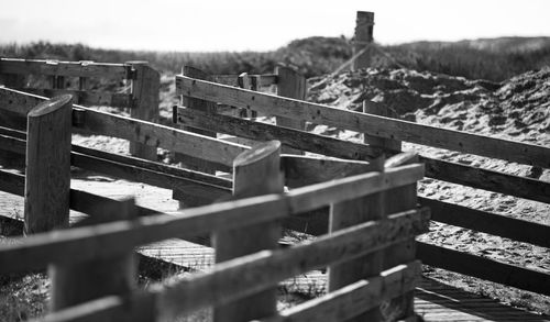 Close-up of wooden fence on field against sky