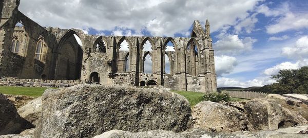 Panoramic view of old ruins against cloudy sky
