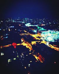 Illuminated cityscape against sky at night