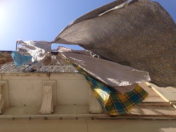 Low angle view of clothes drying on roof against sky