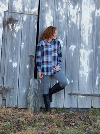 Woman standing against barn