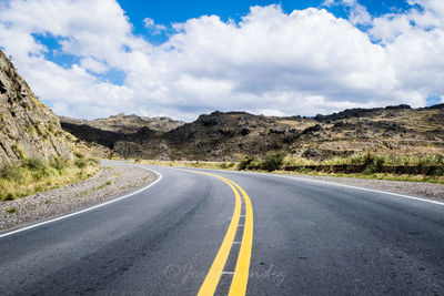 Empty road along landscape against sky