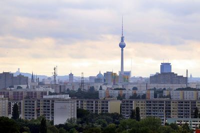 Buildings in city against cloudy sky