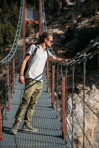 Hiker standing on hanging bridge and looking down to the lake. travel concept