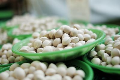 Close-up of pistachios in containers for sale at market stall