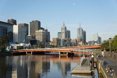 Bridge over river in city against sky