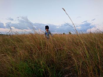 Man standing on field against sky