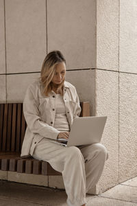 Woman using laptop while sitting outdoors