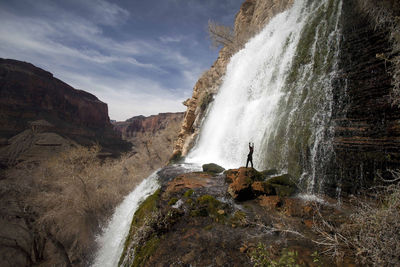Waterfall with a man raising arms