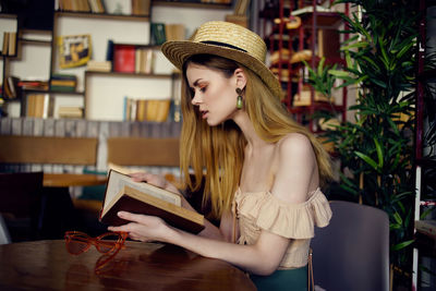 Portrait of young woman sitting on table