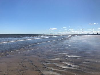 Scenic view of beach against blue sky