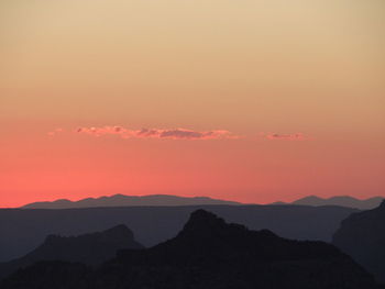 Scenic view of silhouette mountains against romantic sky at sunset