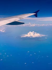 Airplane flying over sea against blue sky