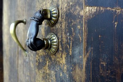 Close-up of doorknob on weathered door