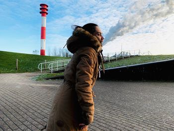 Side view of man standing on footpath