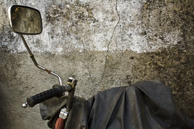 Close-up of old motorcycle against wall