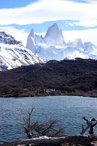 Scenic view of lake and snowcapped mountains against sky