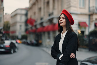 Portrait of young woman standing in city