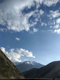 Low angle view of mountains against cloudy sky