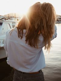 Rear view of woman standing at harbor