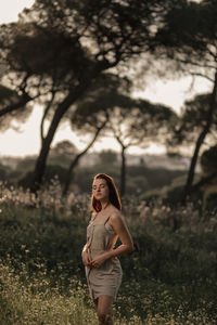 Portrait of young woman standing on field