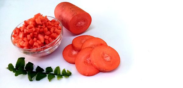 High angle view of chopped fruits on table against white background