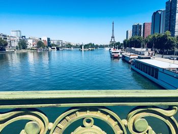 Scenic view of river and buildings against clear blue sky