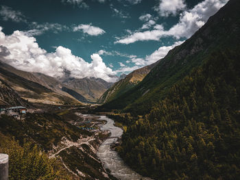 Scenic view of river amidst mountains against sky