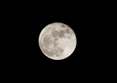 Low angle view of full moon against clear sky at night