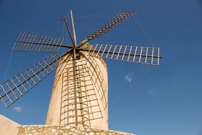 Low angle view of traditional windmill against clear blue sky