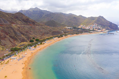 Scenic view of sea and mountains against sky