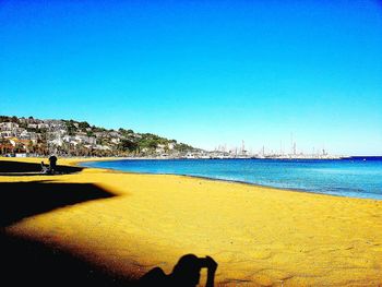 Scenic view of beach against clear blue sky