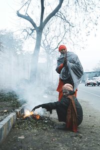 Portrait of sadhu by bonfire during winter