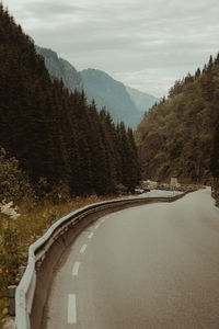 Road amidst trees against sky