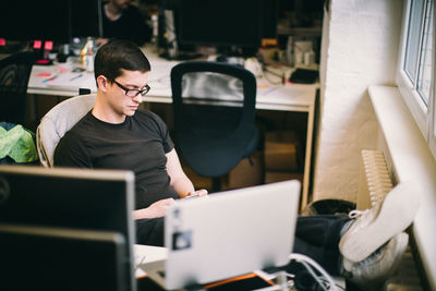 Mid adult man using phone at office