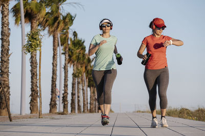 Full length of man and woman wearing sunglasses against sky