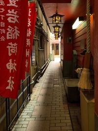 Illuminated footpath amidst buildings