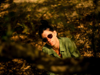 Portrait of young man wearing sunglasses while standing in forest