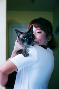 Woman holding cat at home