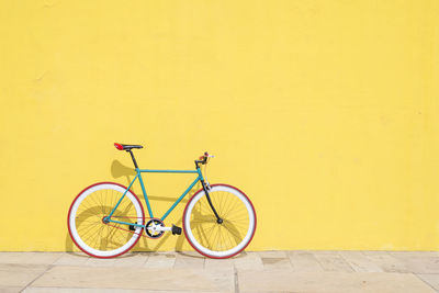 Bicycle on footpath against wall