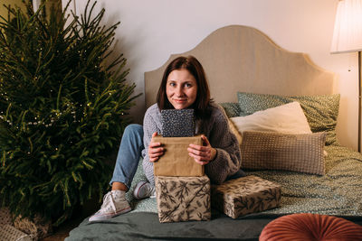 Portrait of young woman sitting on sofa at home